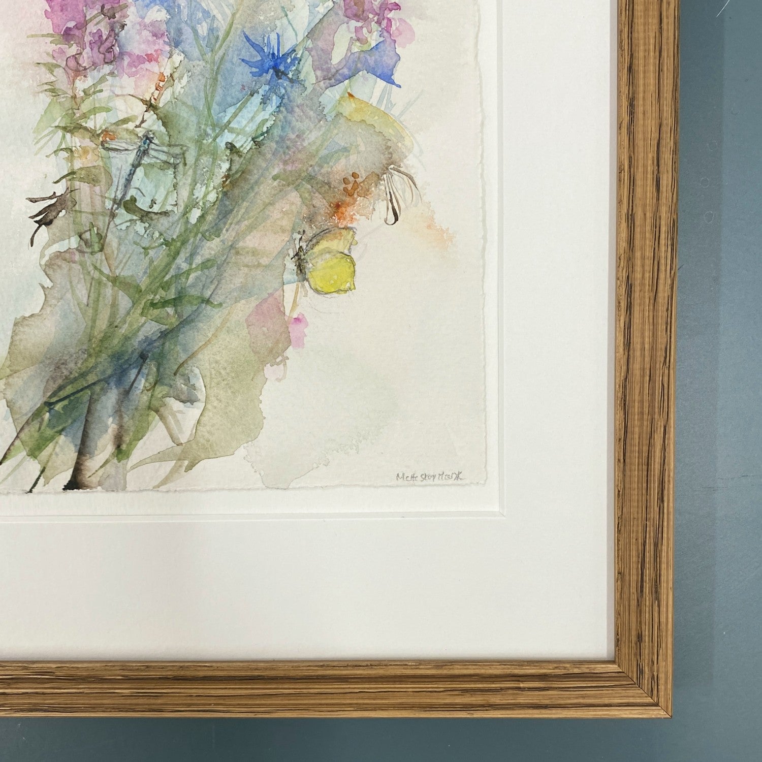 Akvarel med blomster gederams og kornblomst, lyserøde og blå farver. to sommerfugle og en guldsmed. Indrammet i mørk egetræ.